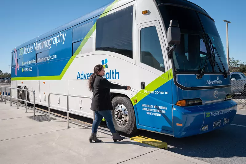 A woman going into an AdventHealth bus that provides mobile mammography