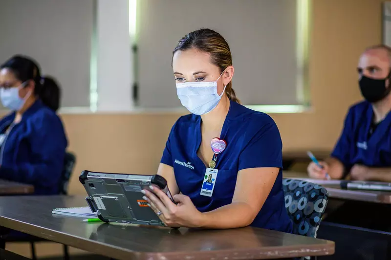A medical employee engaged on a hospital tablet during a training class
