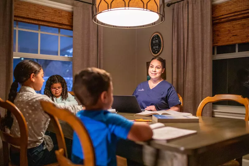 An AdventHealth employee, who's a mother, with her children at home