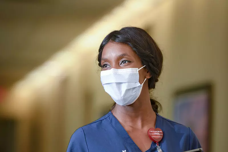 An AdventHealth nurse walking down the hallway with her tablet