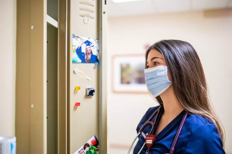 A nurse looking at a graduation photo of herself