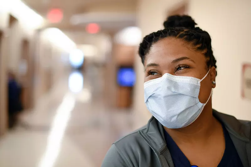 An AdventHealth nurse expressing happiness beneath her face mask