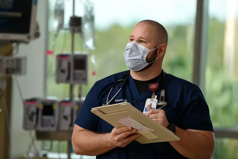 AdventHealth nurse writing on his clipboard