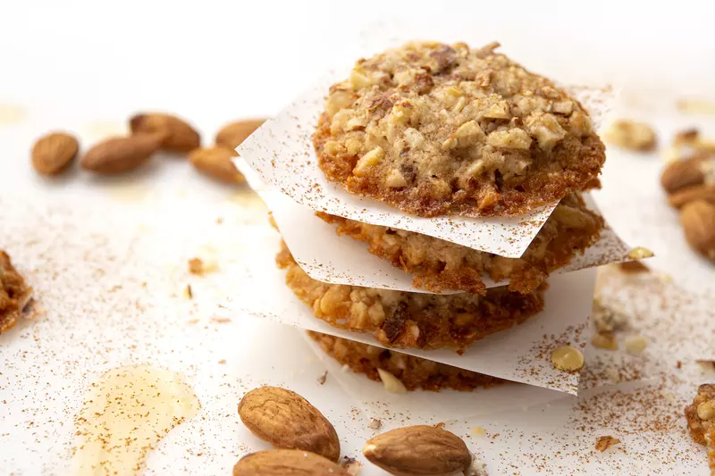 Four stacked almond-maple cookies with almond garnish