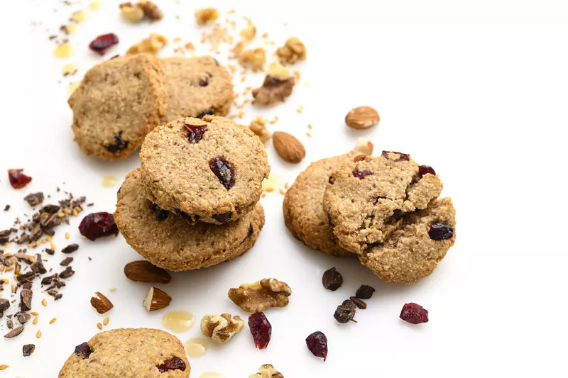 Six cranberry-walnut cookies amid almonds and craisins