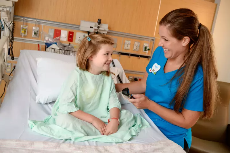 A girl smiles with her nurse