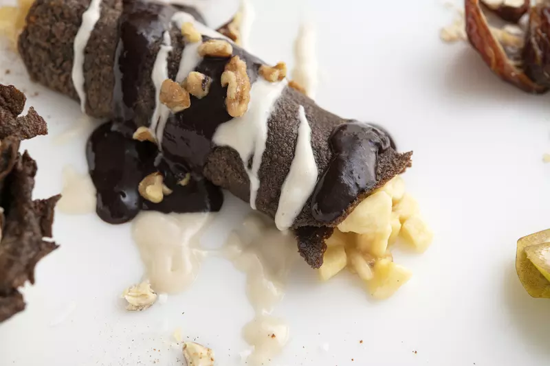 Chocolate crepe with banana filling on white surface