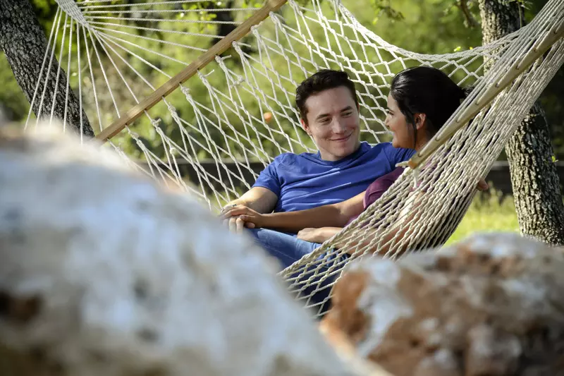 Couple sitting in a hammock outdoors.