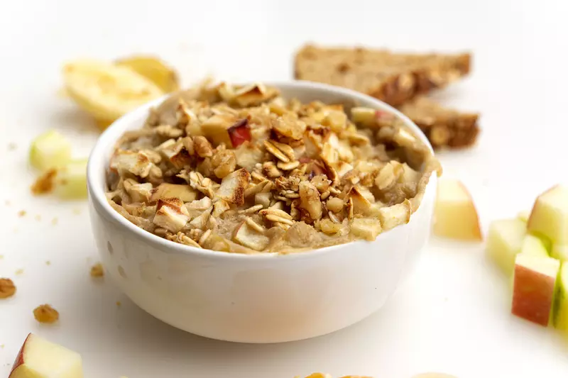 Bowl of cooked apples and oat with apple chunk garnish