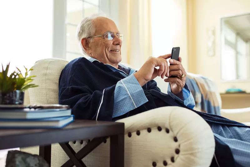 An elderly man relaxing at home seating on his couch.