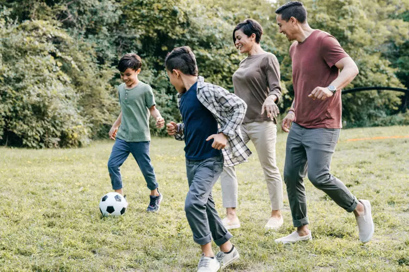 Family playing soccer together at home.