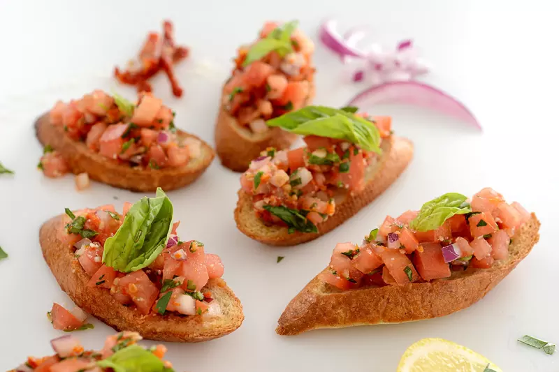 toasted slices of bread, topped with chopped tomato, garlic, onion and basil