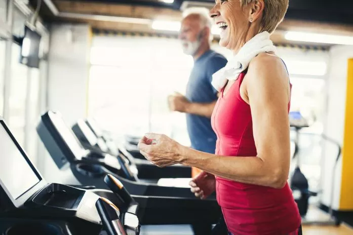 A Senior Couple at the Gym Running on Treadmills