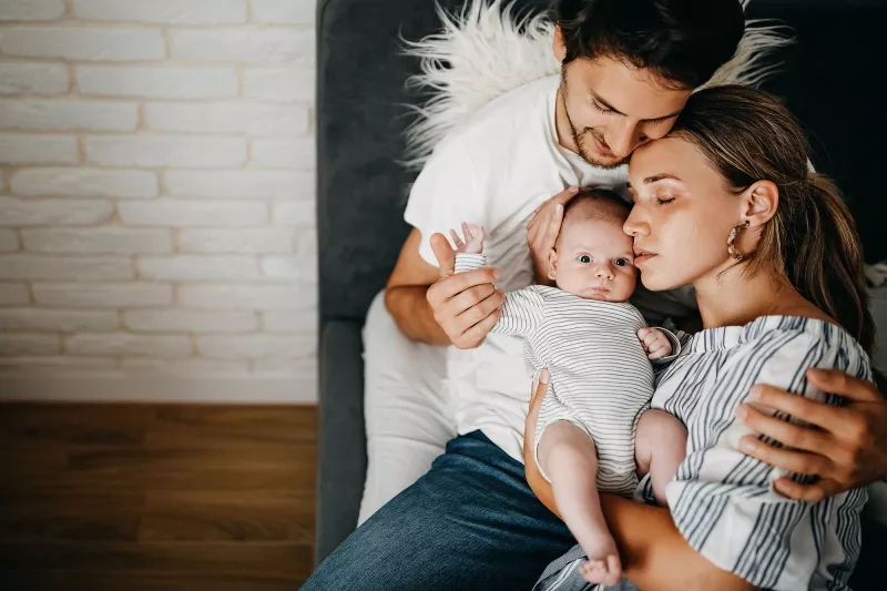 A Mother and Father Hug Their Newborn Baby