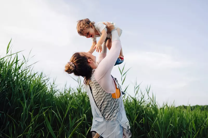 A Mother Holds Her Son to the Sky in a Corn Field