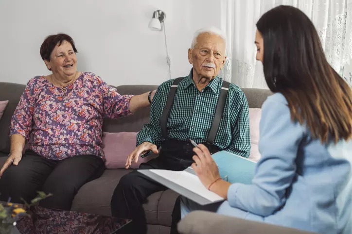 caregiver with eldery couple at home 