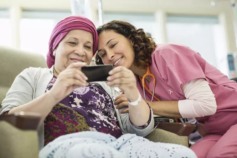 A young nurse and her female cancer patient taking a sweet selfie.