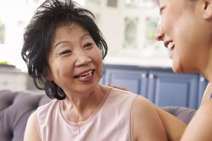 A Senior Woman Speaks to Her Daughter on a Couch at Home