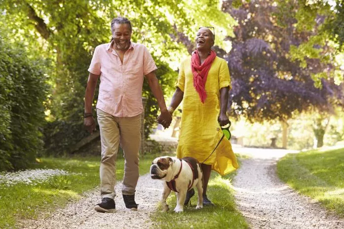 A Couple Walks Their Dog Through the Park