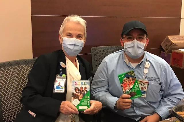 Medical professionals holding boxes of girl scout cookies