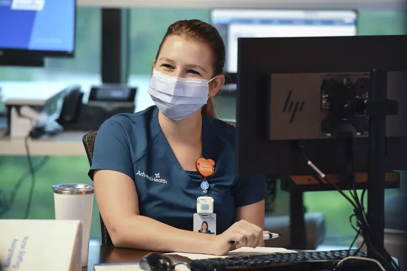 An AdventHealth employee working at a computer. 