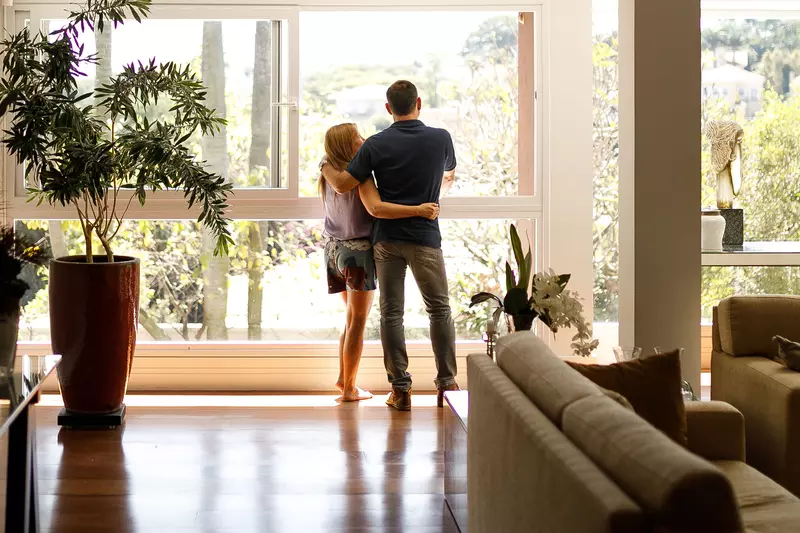 A couple hugging and looking out a window.