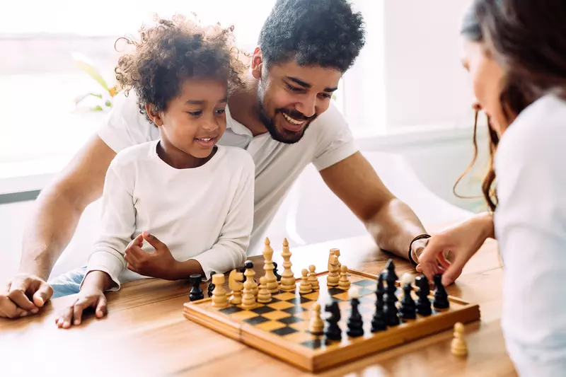 A family playing chess together. 