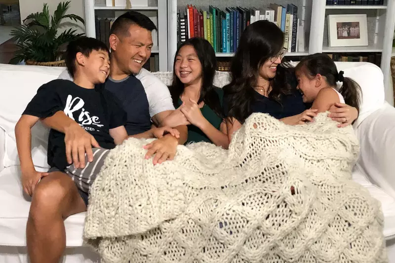 Family laughing on couch