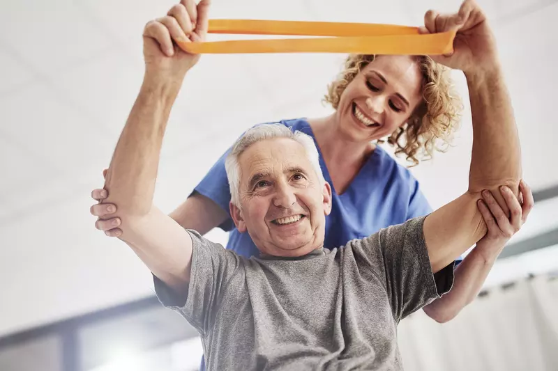 An older man receives physical therapy. 