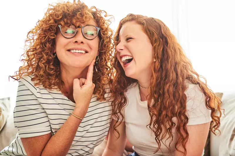 A mother and daughter joking and laughing together. 