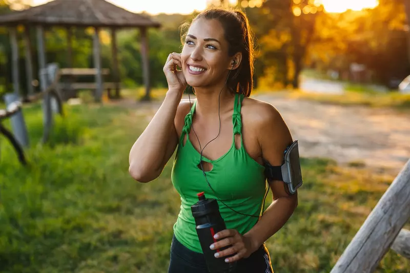A woman preparing to go on a run outdoors.