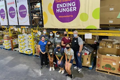 A group of volunteers in front of boxes of donated food