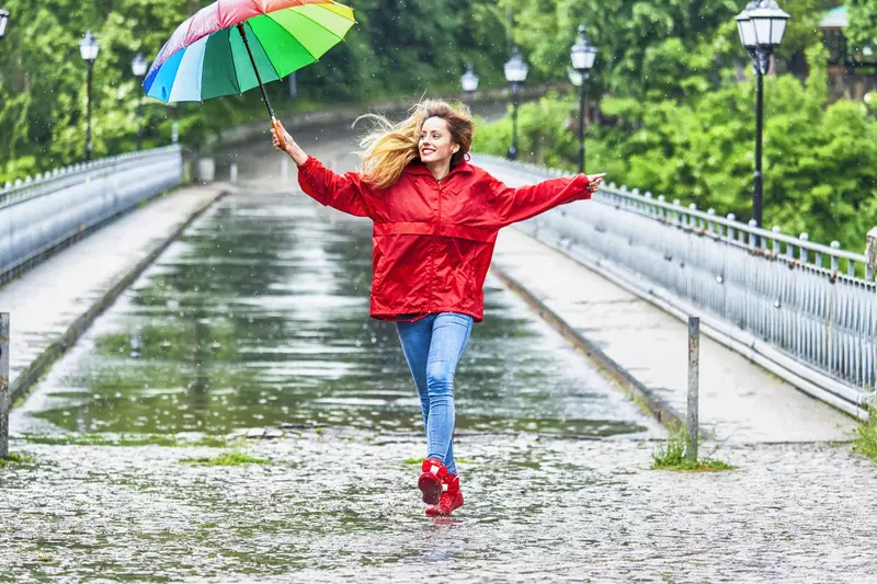 A woman dances in the rain.
