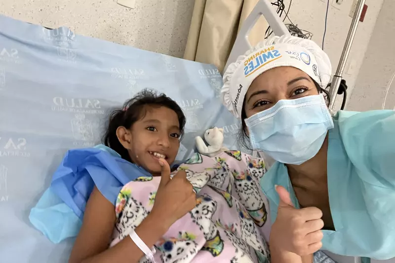 a nurse and a girl giving a thumbs up