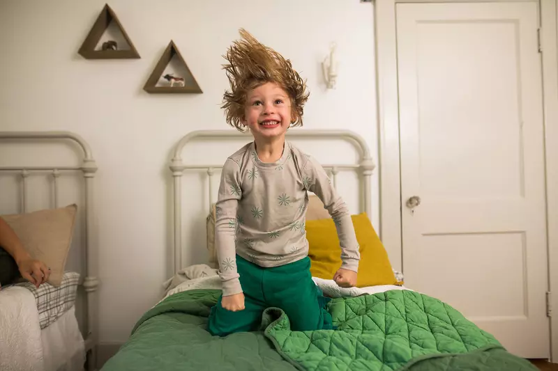 Little boy jumping on the bed.