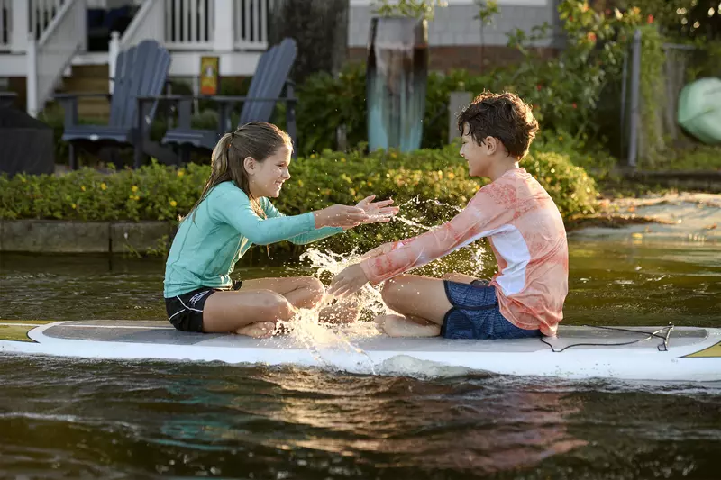 Kids on a Paddleboard splashing water.
