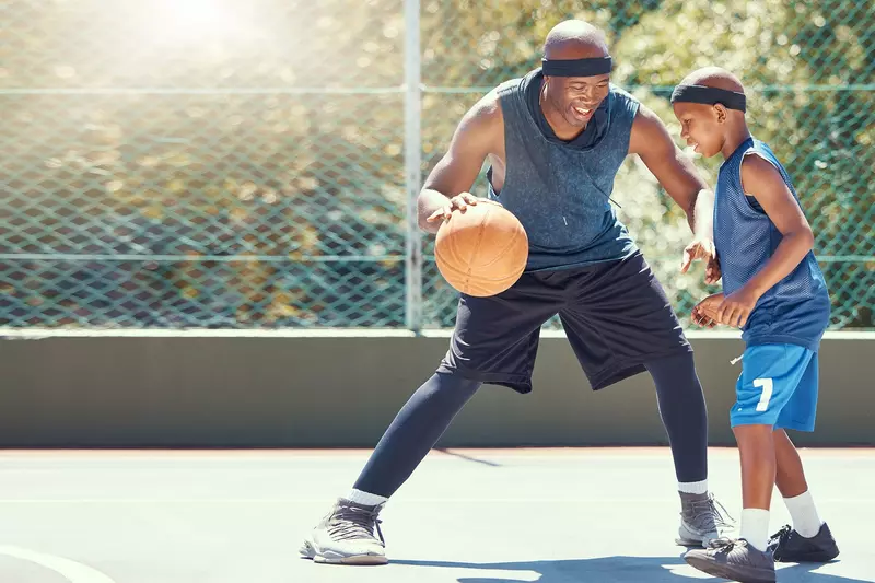 A Father and Son Play Basketball on a outdoor court