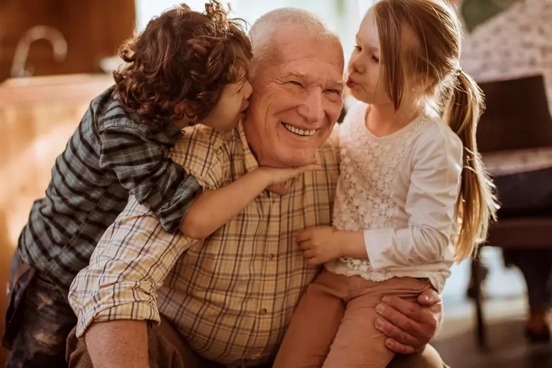 Children greeting Grandpa with a group hug.