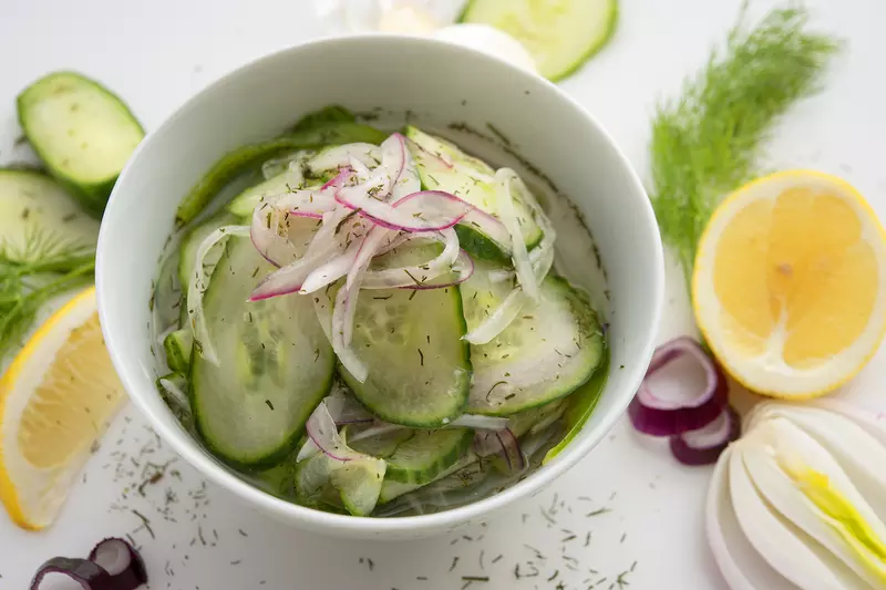 Bowl of cucumber-dill relish with lemon and cucumber garnishes