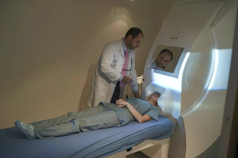 A patient undergoing a MEG scan while a physician oversees the procedure.