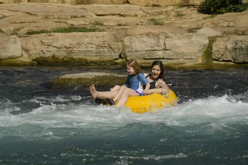 Mother and daughter tubing down a river.