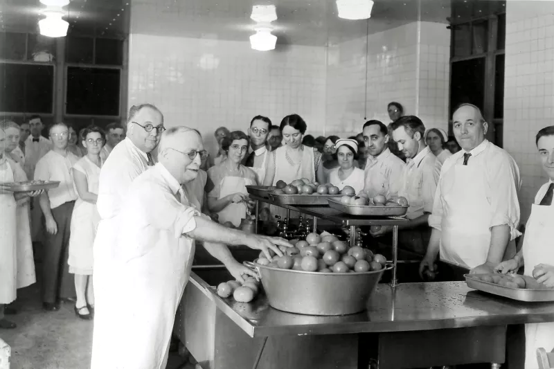 John Harvey Kellogg and staff in a kitchen.