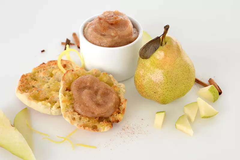 dish and muffin with pear and date sauce next to a whole pear and pear pieces
