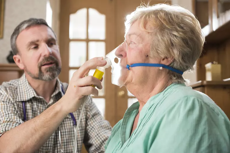 A doctor giving an athsma patient some oxygen through mask