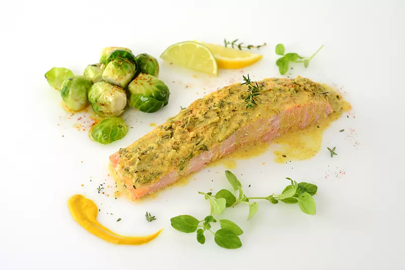 Herb-crusted salmon filet with Brussels sprouts and herb garnish