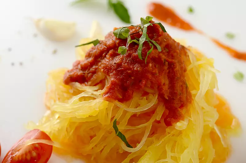 Mound of spaghetti squash topped with marinara and herbs 