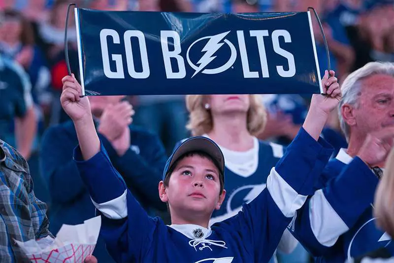 Young Tampa Bay Lightning fan holding a "Go Bolts" sign.