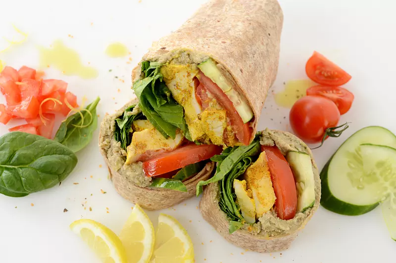 Sliced chicken wrap with vegetable and lemon garnishes