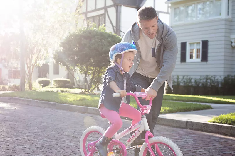 Dad taking his daughter on a bike ride.