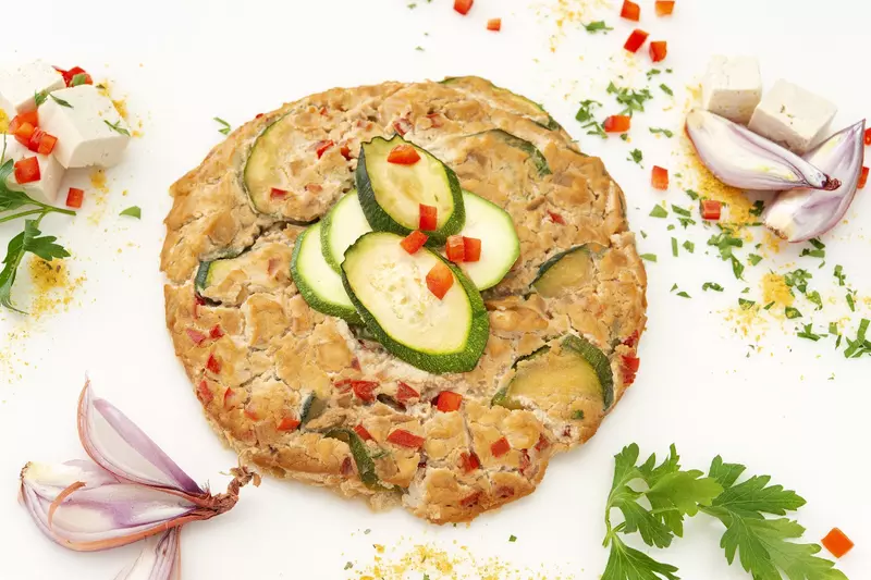 a flat, plant-based frittata, with zucchini and red bell peppers
